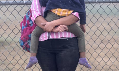 A Central American mother holds her child while waiting to be processed by Border Patrol agents in La Joya, Texas, 10 April 2021.