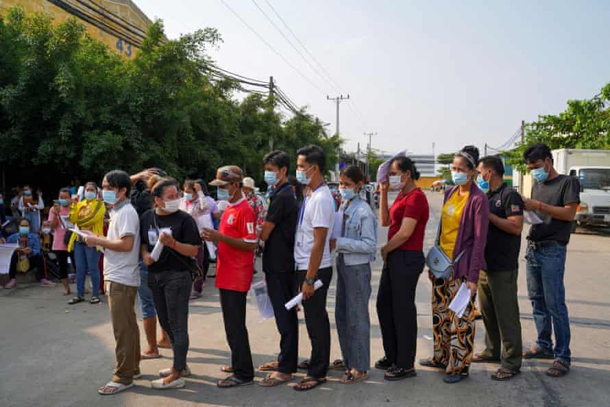 Garment factory workers and staff wait to receive the Sinovac vaccine.