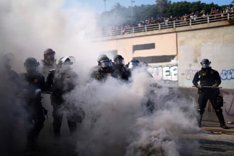 Police are seen through smoke on the 101 Freeway near the Metropolitan Detention Center of downtown Los Angeles, Sunday, 8 June, 2025, following last night's immigration raid protest.