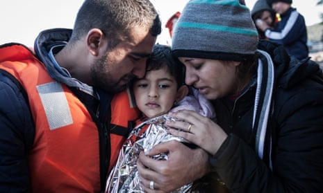 A boy is comforted by his parents after landing on Lesbos, Greece on Thursday.