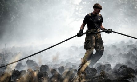 A firefighter tackles a wildfire blaze in in Shiregreen, Sheffield, caused by the heatwave in July 2022.