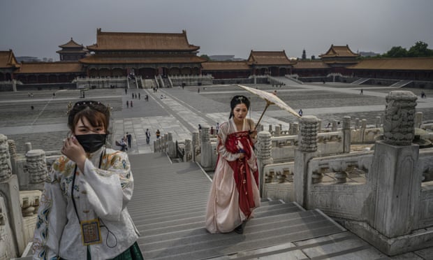 Chinese women dressed in traditional costume known as Hanfu tour the Forbidden City in Beijing