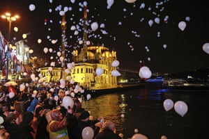 People release balloons and lanterns in Istanbul’s Ortakoy district, by the Bosphorus