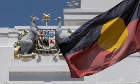Aboriginal flag flying in front of Australia coat of arms on parliament house