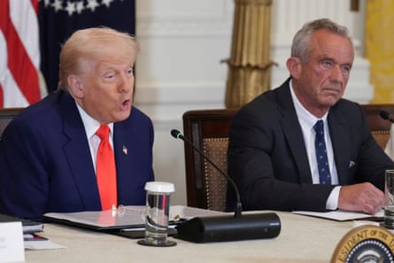 Donald Trump speaks into a microphone as RFK Jr sits next to him listening