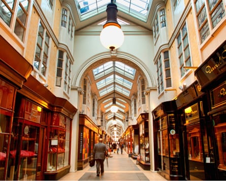 View down a very smart covered arcade of shops including jewellers.