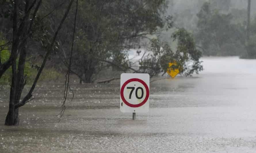 Traffic signs sit submerged along a flooded road in Londonderry on the outskirts of Sydney on Monday.