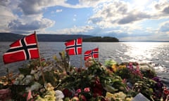 Norwegian flags and flowers are seen in Sundvollen, close to Utoya island, background, where gunman Anders Behring Breivik killed at least 68 people, near Oslo, Norway, Thursday July 28, 2011. (AP Photo/Lefteris Pitarakis)