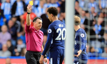 Referee Mr Neil Swarbrick shows Dele Alli of Tottenham Hotspur a yellow card for diving against Huddersfield Town.