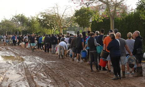People line up to collect water from a broken pipe after flooding hit large parts of the country on October 31, 2024 in the Paiporta municipality of Valencia, Spain. By Thursday, Spanish authorities confirmed that at least 95 people had died, mostly in the Valencia region, amid the flooding that swept eastern and southern parts of the country starting on Tuesday. The intense rainfall event is known as a "cold drop" or DANA weather system. (Photo by David Ramos/Getty Images)