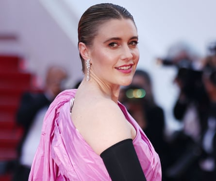 woman in pink and black dress looks over shoulder