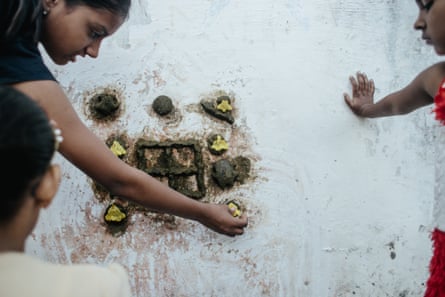 At the entrance of their homes, girls in Piplantri make patterns with flowers.