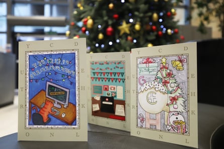 The three winning card designs displayed in front of a Christmas tree