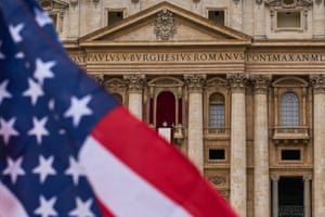 The pope on a balcony as a US flag fills the foreground in half of the picture