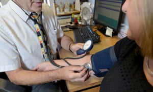 a doctor checking a patient’s blood pressure
