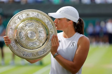 Iga Swiatek kisses the Wimbledon trophy