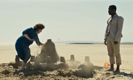 Olivia Colman destroying a large sandcastle on a beach as Micheal Ward looks on in a scene from Empire of Light