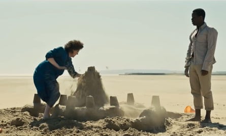 Hillary (Olivia Colman) begins destroying a sand castle she and Steven (Michael Ward) have built on the beach.