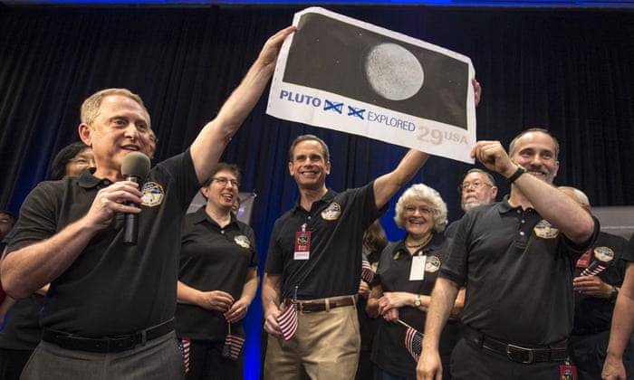 New Horizons principal investigator Alan Stern, left, Johns Hopkins University applied physics laboratory director Ralph Semmel, centre, and New Horizons co-investigator Will Grundy hold a print of a US stamp with their suggested update. At center right under the stamp is Annette Tombaugh, daughter of Pluto’s discoverer, Clyde Tombaugh.