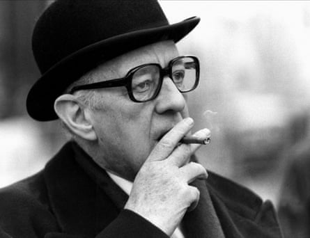A black-and-white, head and shoulders shot of Alec Guinness in the film, smoking a cigar