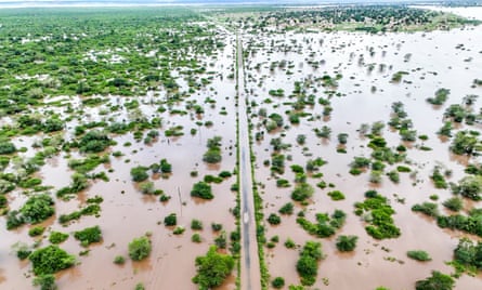Aerial view of flood waters covering a road and surrounding rural area