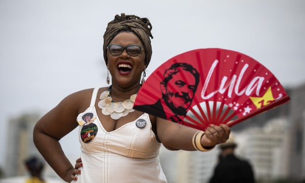 A woman holds a fan with the image of 'Lula' da Silva during a Black Women's March in Rio de Janeiro, 31 July.
