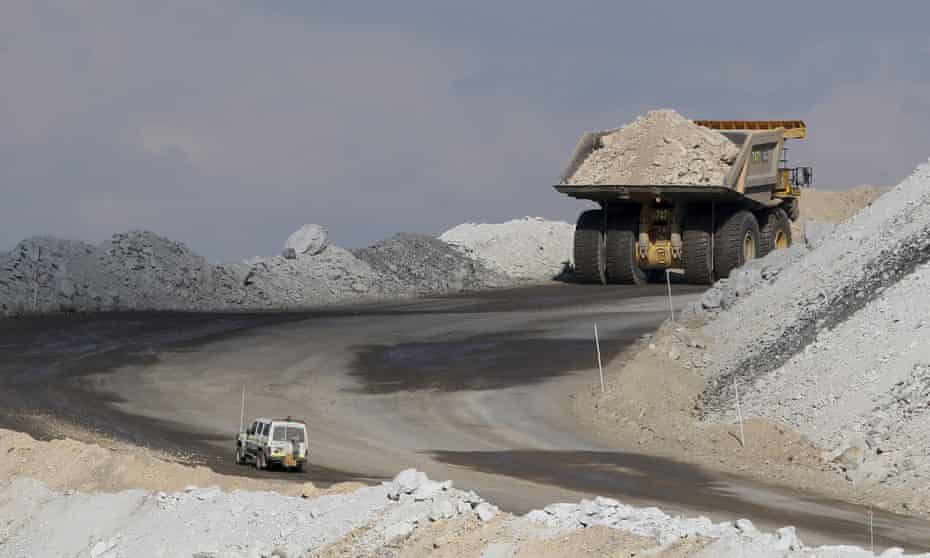 Four-wheel-drive vehicle follows a large mining truck as it makes its way to the top of a coalmine