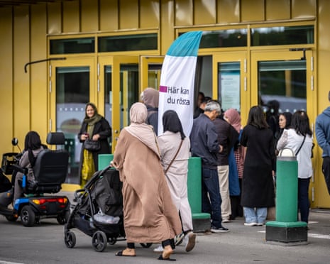 People wait in line at a polling station in Rosengård, Sweden to give their vote.
