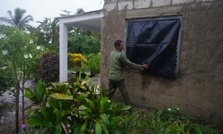 El agricultor Cito Braga pone plástico en una ventana de su casa en Coloma, Cuba, antes de la llegada del huracán Ian