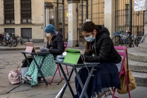 Anita Iacovelli, left, and her friend Lisa Rogliatti, both 12, sit in front of the Italo Calvino school in Turin, Italy.