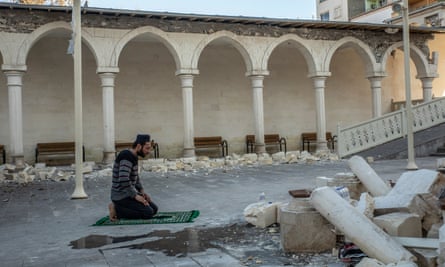 A man prays in a damaged mosque in Pazarcık