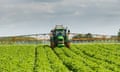 A tractor spraying of potato crops with chemical pesticides