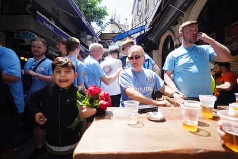 A young boy hawks flowers to Manchester city fans in Istanbul.