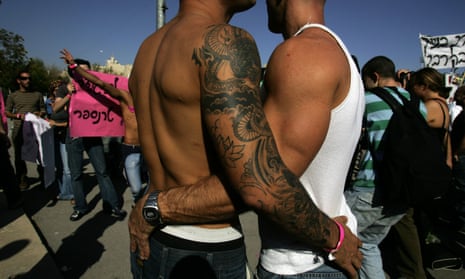 Two gay men embrace at a protest.