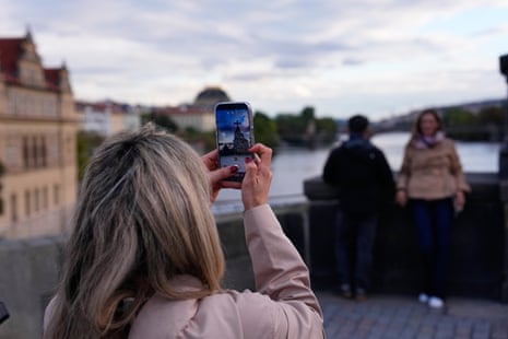 A woman takes a photo of two people recreating the Depeche Mode picture.