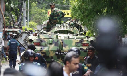 Bangladeshi soldiers and security personnel sit on top of armoured vehicles in a diplomatic zone of the capital, Dhaka.