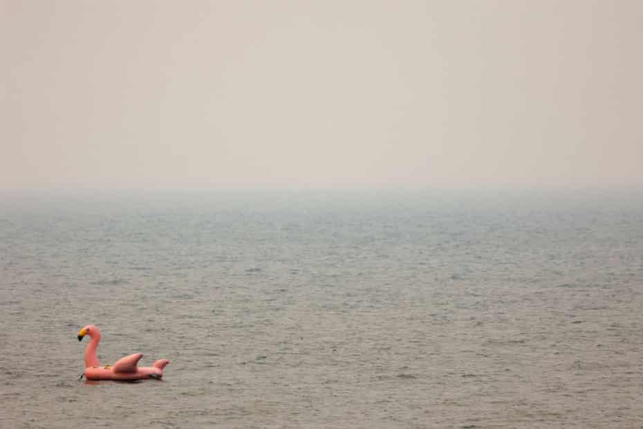 A giant inflatable flamingo floats on Lake Tahoe as smoke from the Caldor fire is thick in the air.