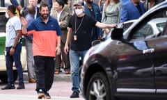 Adam Sandler, who has worn slippers and shorts to film premieres, waves to fans in Philadelphia, Pennsylvania.