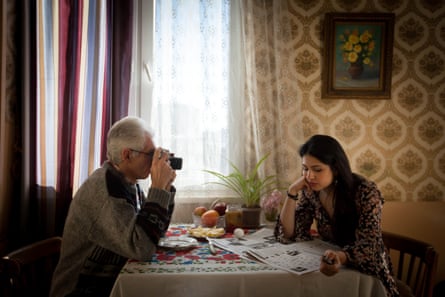 An image from the Father series of father and daughter sitting across each other at a table.