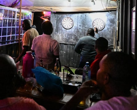 Members of G9 play darts at Mnazini bar and restaurant Ruaka.