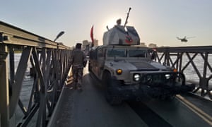 Iraqi solders next to an armoured vehicle in Mosul