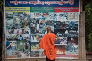 A Buddhist novice looks at pictures outside Ashin Wirathu’s quarters showing atrocities allegedly committed by Muslims against Buddhists