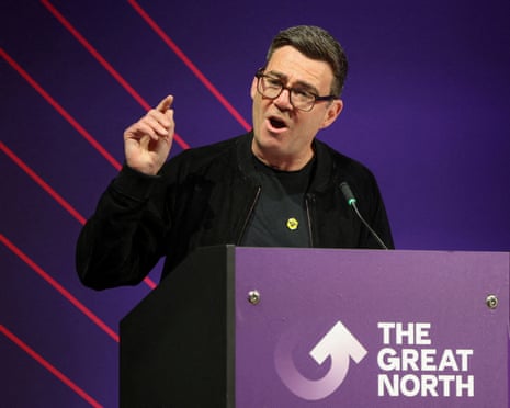 Andy Burnham gestures while speaking at a podium with The Great North branded backdrop
