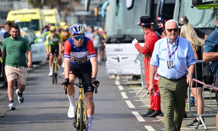 Tour of Britain winner Wout van Aert rides past race director Mick Bennett (right).