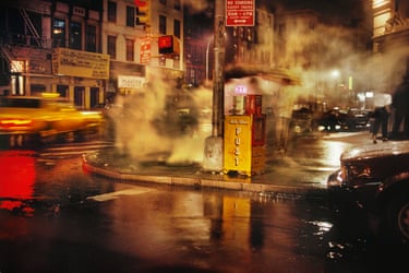 steam rising over a busy road junction at night
