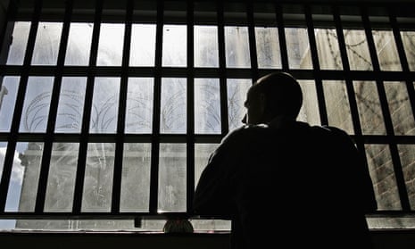 Man looking out from behind prison bars