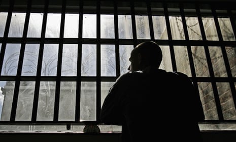 A prisoner looks out of the window of a young offenders' institution. 