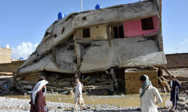 People outside partially collapsed house