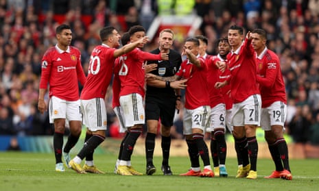 Referee Craig Pawson is surrounded after booking Cristiano Ronaldo.
