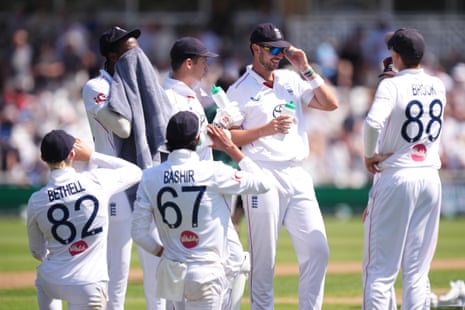 England cricketers gather together during a break, some holding drinks, on the first day of the third Test against New Zealand